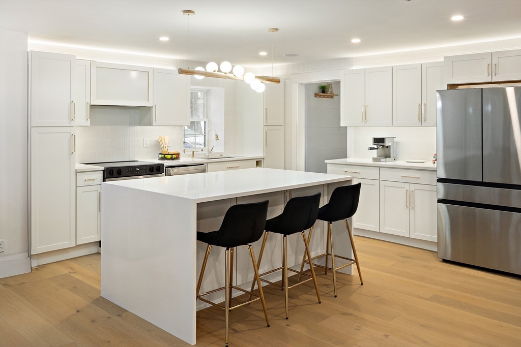 355 Maynard Road Sudbury, MA 01776 - Photo 8 of 18 a kitchen with kitchen island granite countertop a stove a refrigerator a sink a dining table and chairs