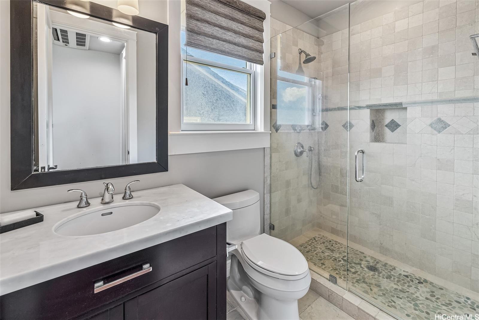 4125 Black Point Road Honolulu, HI 96816 - Photo 21 of 25 a bathroom with a sink toilet a mirror and shower