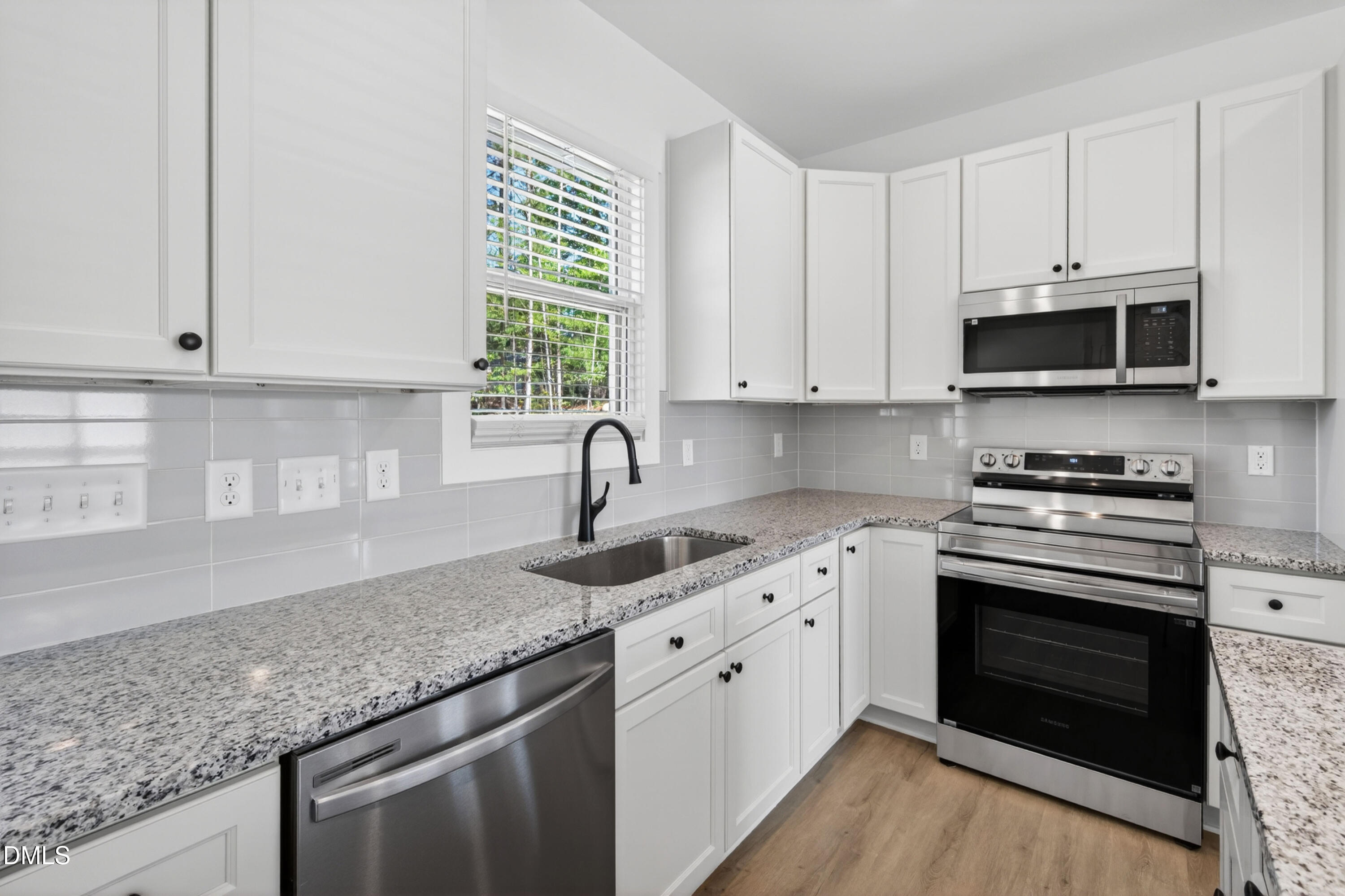1196 Hurdle Mills Road Roxboro, NC 27573 - Photo 18 of 50 a kitchen with stainless steel appliances granite countertop a sink dishwasher a stove and a microwave oven with cabinets