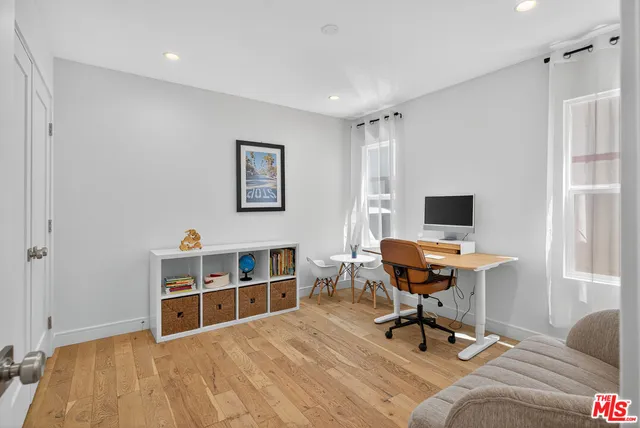 a view of a workspace with furniture and a window