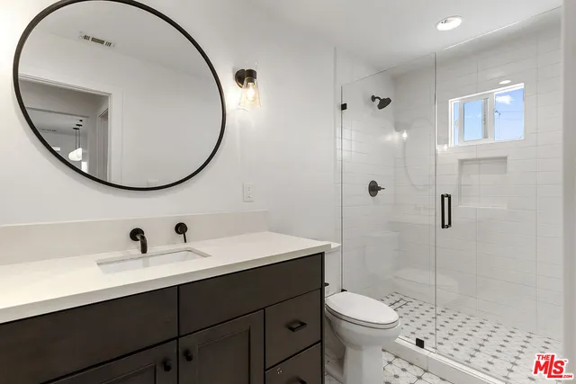 a bathroom with a sink a toilet and a mirror