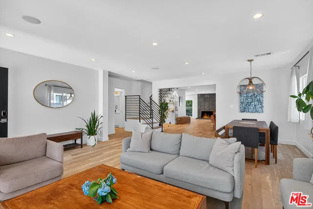 a living room with furniture potted plant and a wooden floor