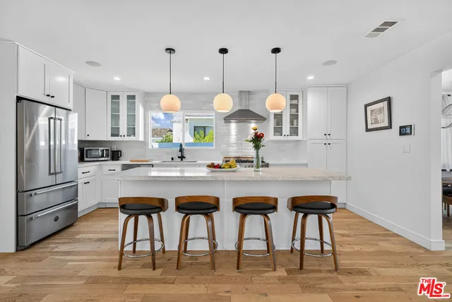 a kitchen with granite countertop a sink cabinets and stainless steel appliances
