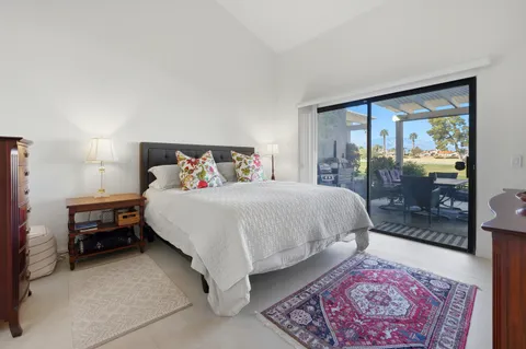 a bedroom with a bed lamp and a rug