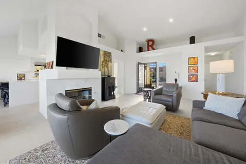 a living room with furniture a flat screen tv and a fireplace