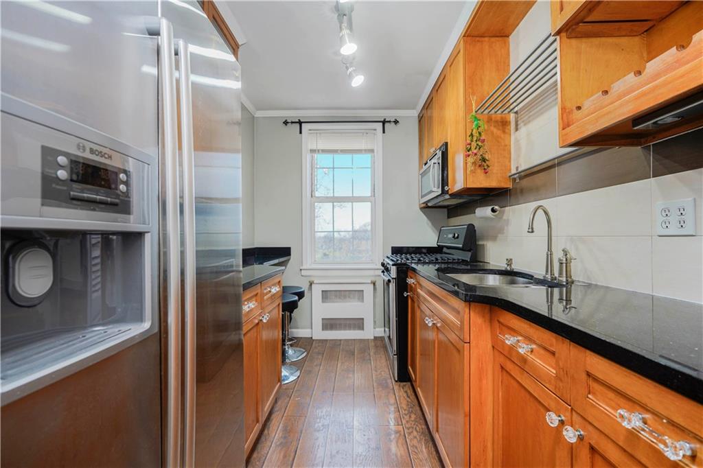 6665 Colonial Road, Unit 6E Brooklyn, NY 11220 - Photo 11 of 22 a kitchen with stainless steel appliances granite countertop a stove a sink and a microwave