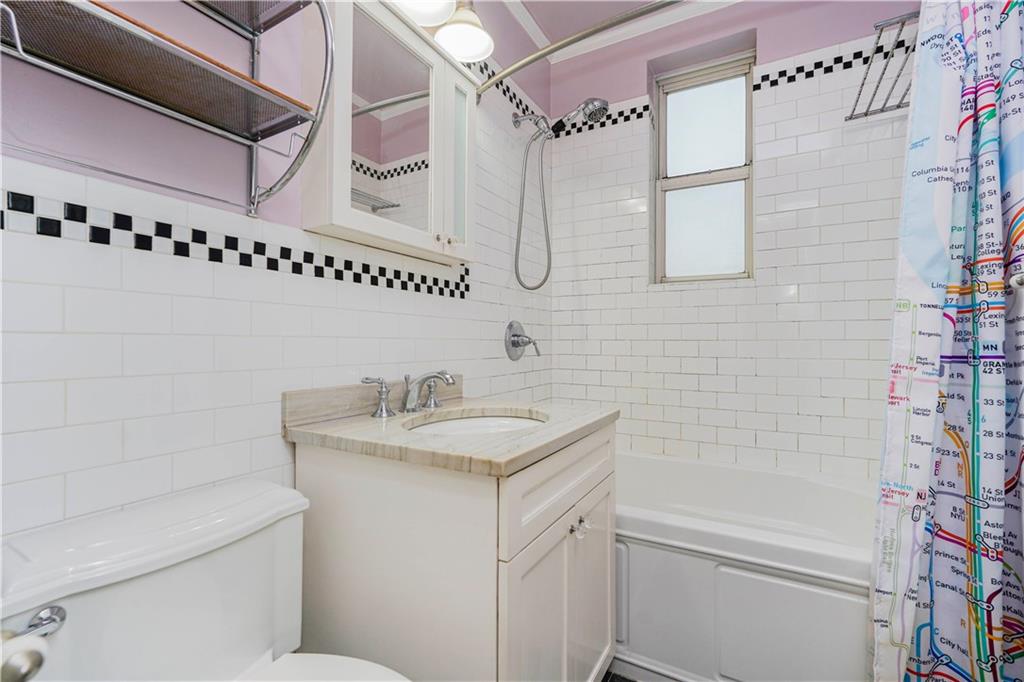 6665 Colonial Road, Unit 6E Brooklyn, NY 11220 - Photo 19 of 22 a bathroom with a granite countertop sink a toilet and shower