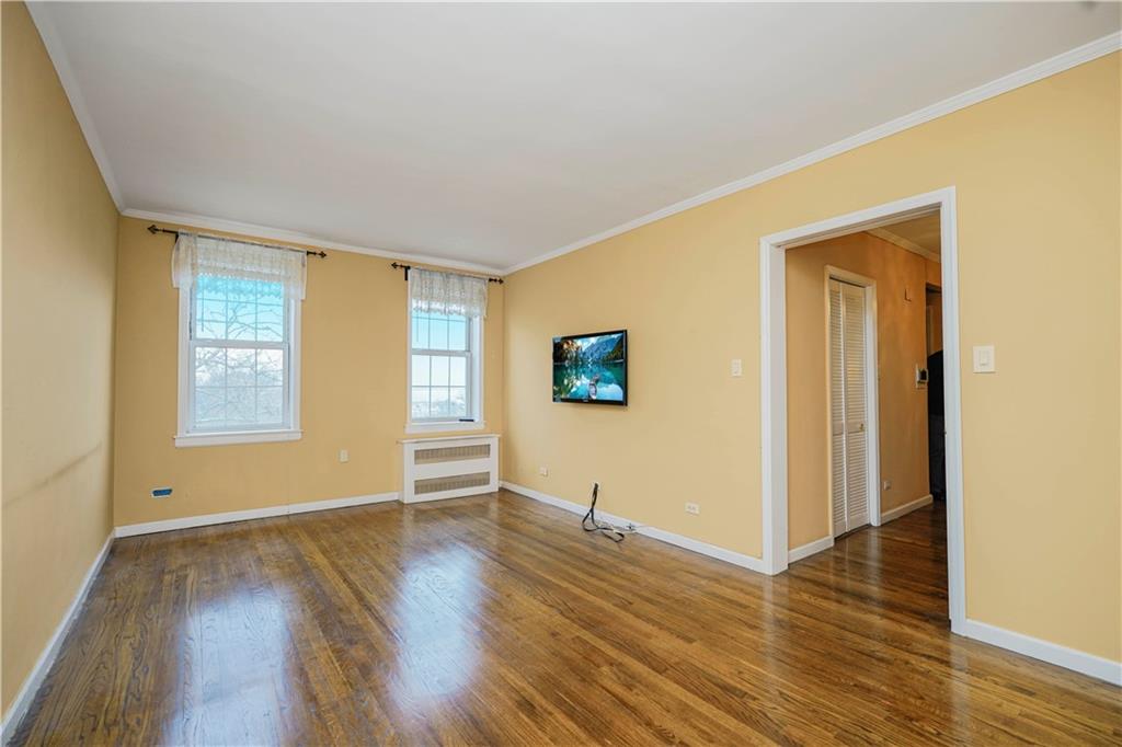 6665 Colonial Road, Unit 6E Brooklyn, NY 11220 - Photo 5 of 22 a view of empty room with wooden floor and fan