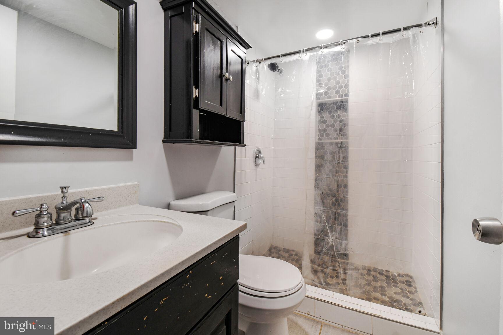 9604 Lanham Severn Road Lanham, MD 20706 - Photo 27 of 30 a bathroom with a sink toilet a mirror and shower
