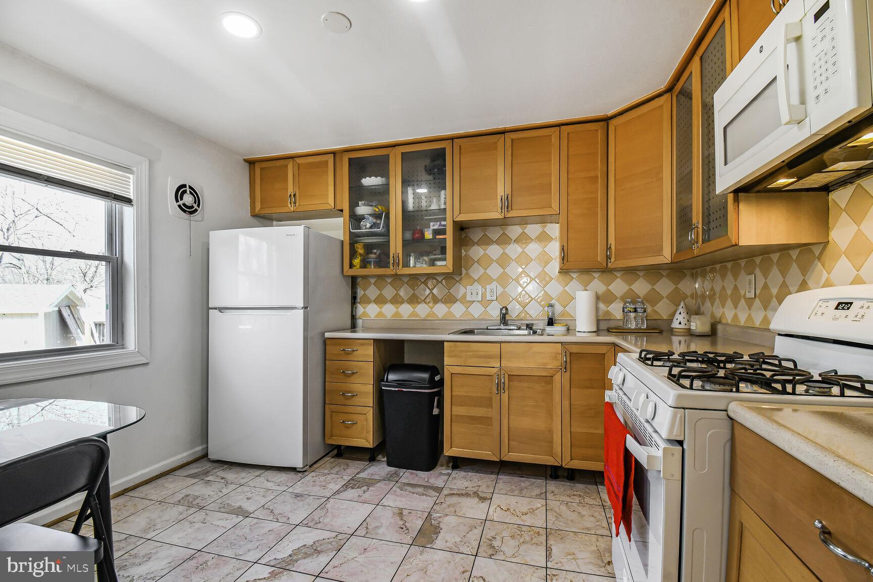 9604 Lanham Severn Road Lanham, MD 20706 - Photo 8 of 30 a kitchen with a refrigerator a stove a sink and cabinets