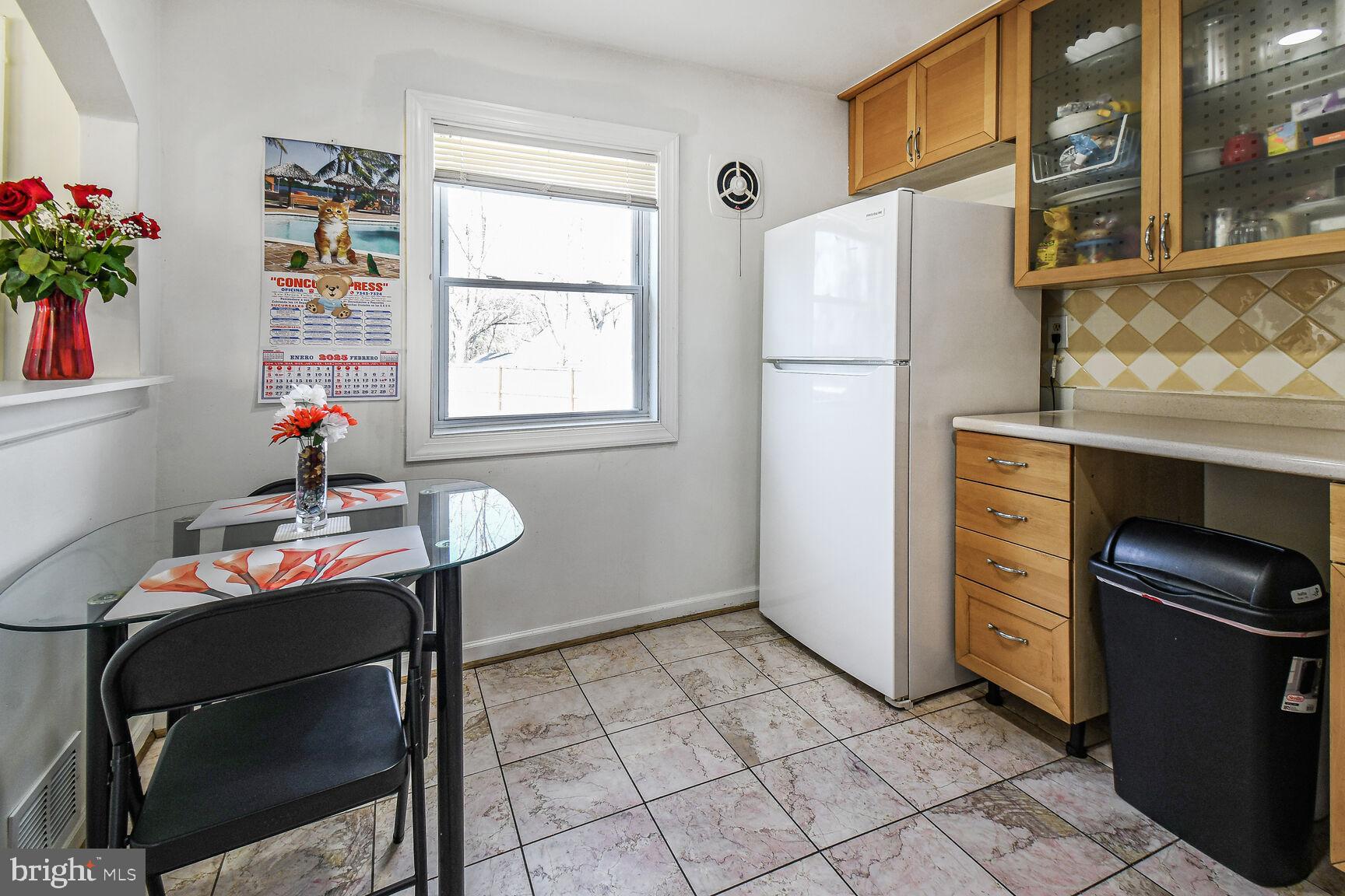 9604 Lanham Severn Road Lanham, MD 20706 - Photo 9 of 30 a kitchen with a refrigerator and table chair