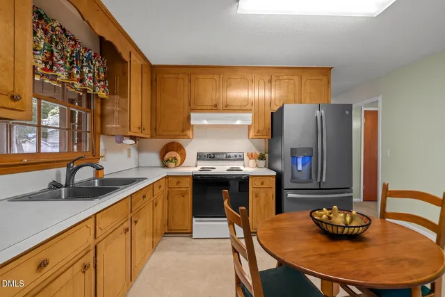 a kitchen with stainless steel appliances granite countertop a sink and a refrigerator