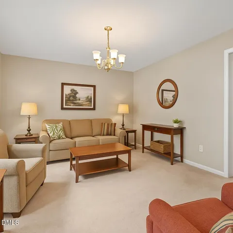 a living room with furniture a wall paintings and a lamp