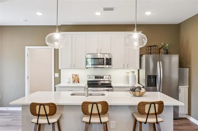 a kitchen with stainless steel appliances granite countertop a sink a refrigerator and a stove