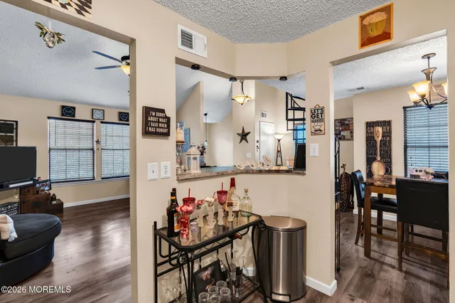 a dining room with wooden floor a chandelier a wooden table and chairs