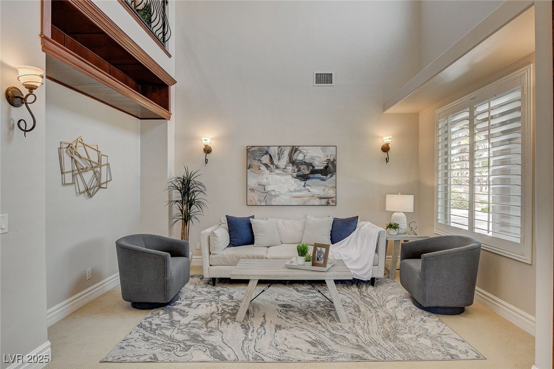 1182 Thomas Bay Circle Logandale, NV 89021 - Photo 14 of 98 Carpeted living room featuring newly painted baseboards and a towering ceiling