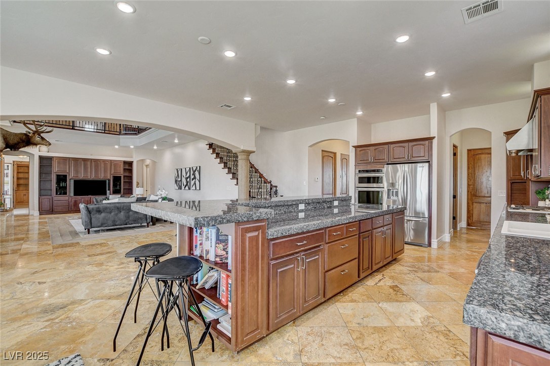 1182 Thomas Bay Circle Logandale, NV 89021 - Photo 28 of 98 Kitchen with appliances with stainless steel finishes, arched walkways, a breakfast bar, recessed lighting, and a spacious island