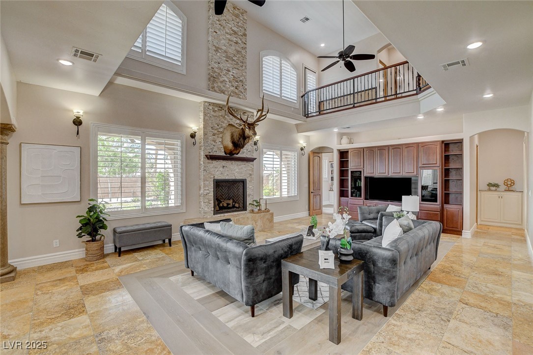 1182 Thomas Bay Circle Logandale, NV 89021 - Photo 36 of 98 Living room with arched walkways, a high ceiling, ceiling fan, a fireplace