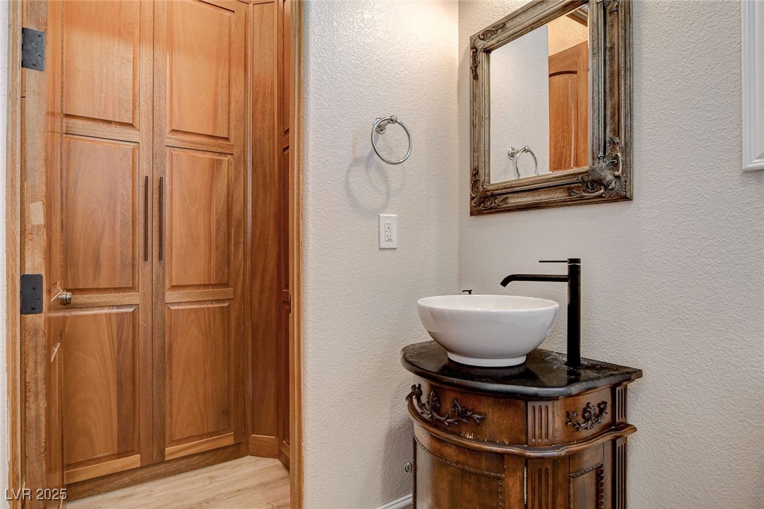 1182 Thomas Bay Circle Logandale, NV 89021 - Photo 46 of 98 Bathroom with a textured wall, vanity, and wood finished floors. Custom closet.