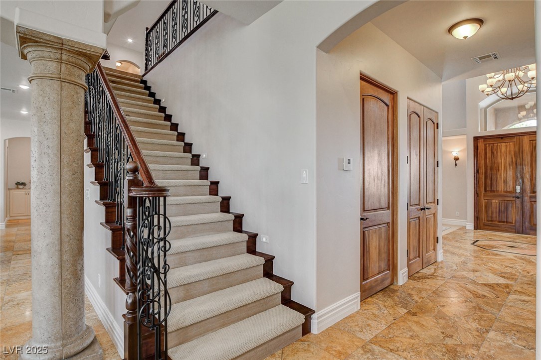 1182 Thomas Bay Circle Logandale, NV 89021 - Photo 50 of 98 Stairway featuring arched walkways, a chandelier, and a high ceiling