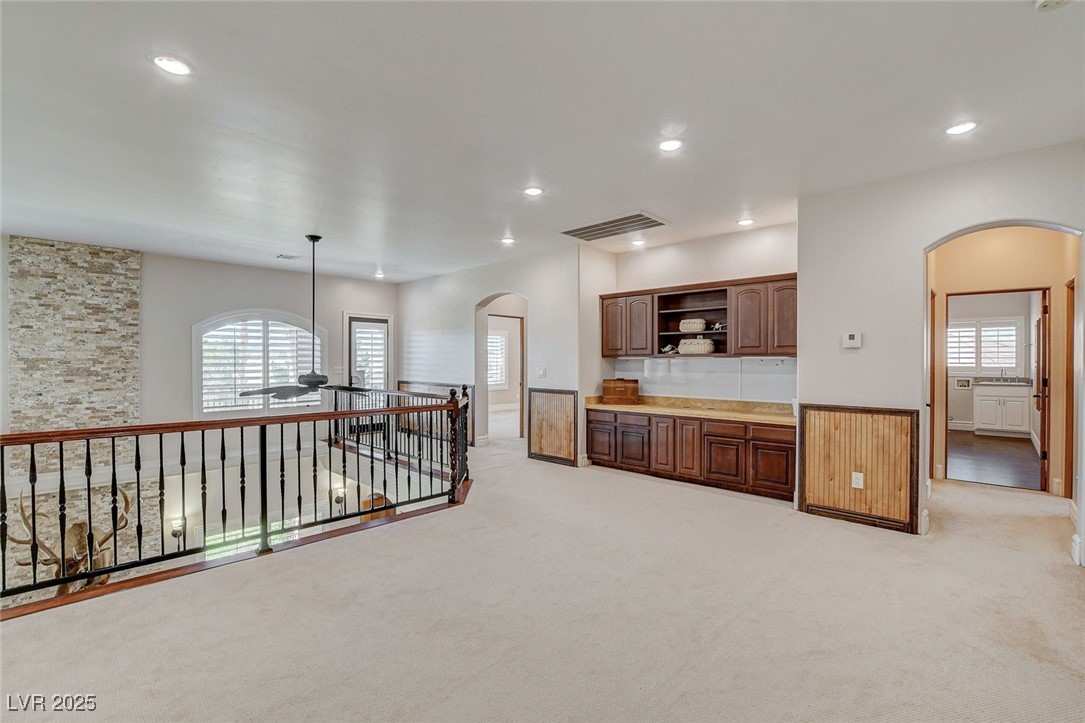 1182 Thomas Bay Circle Logandale, NV 89021 - Photo 52 of 98 Loft or game room with arched walkways, open shelves, a ceiling fan, light carpet, and recessed lighting