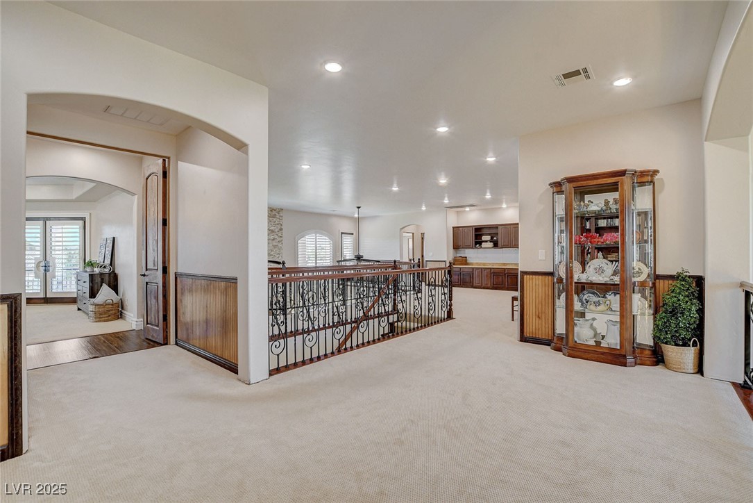 1182 Thomas Bay Circle Logandale, NV 89021 - Photo 62 of 98 Loft off primary bedroom featuring carpet flooring, arched walkways, recessed lighting, an upstairs landing, and french doors
