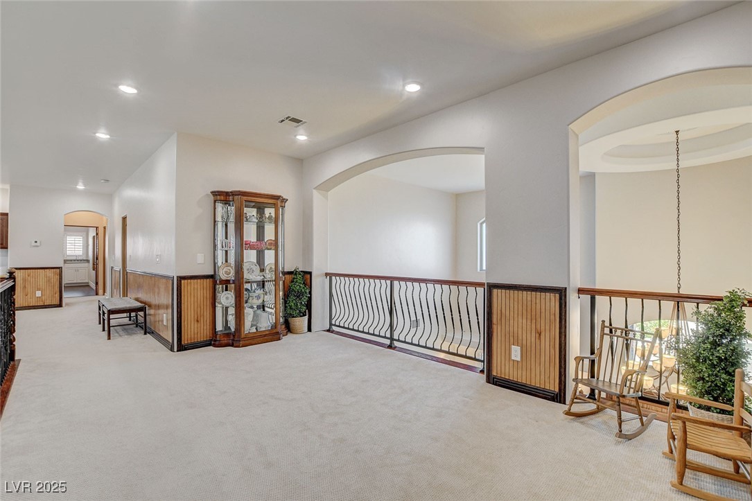1182 Thomas Bay Circle Logandale, NV 89021 - Photo 63 of 98 Loft featuring carpet flooring, arched walkways, plenty of natural light, wainscoting, and recessed lighting