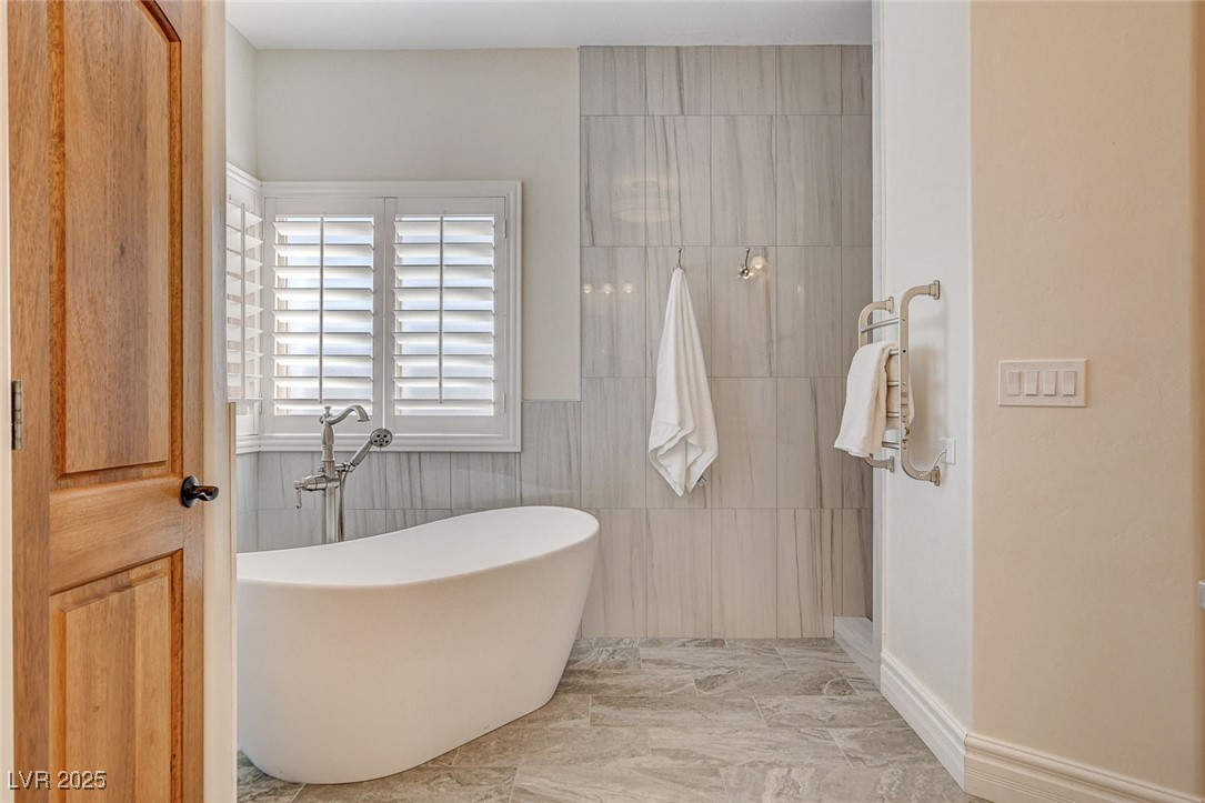 1182 Thomas Bay Circle Logandale, NV 89021 - Photo 72 of 98 Full bathroom featuring a soaking tub, tiled shower, and marble like finish flooring