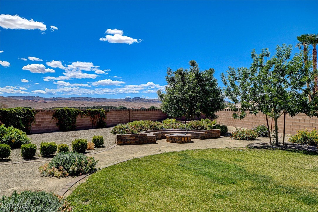1182 Thomas Bay Circle Logandale, NV 89021 - Photo 87 of 98 Fenced backyard featuring a built in fire pit sitting area and a mesa view