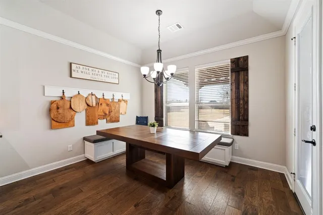 a view of a dining room with furniture wooden floor and chandelier