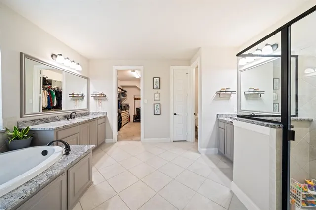 a spacious bathroom with a tub sink and mirror