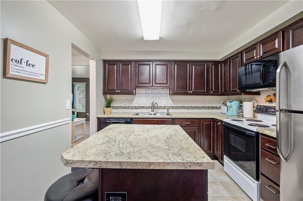 501 Cherry Court Pittsburgh, PA 15237 - Photo 8 of 25 a kitchen with kitchen island granite countertop wooden cabinets a sink and dishwasher