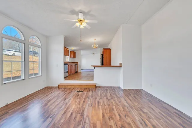 a view of a house with a yard and large tree