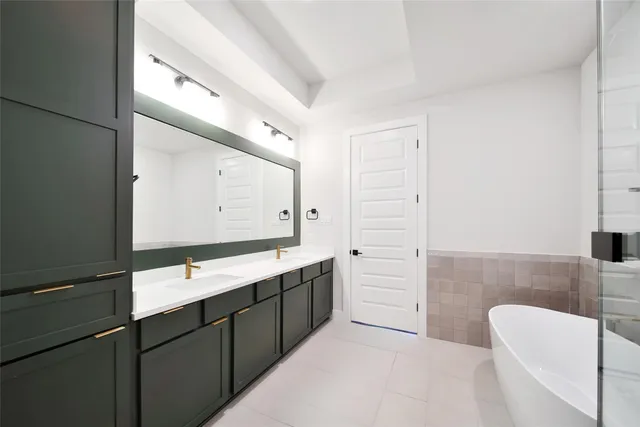 a bathroom with a double vanity sink mirror and bathtub