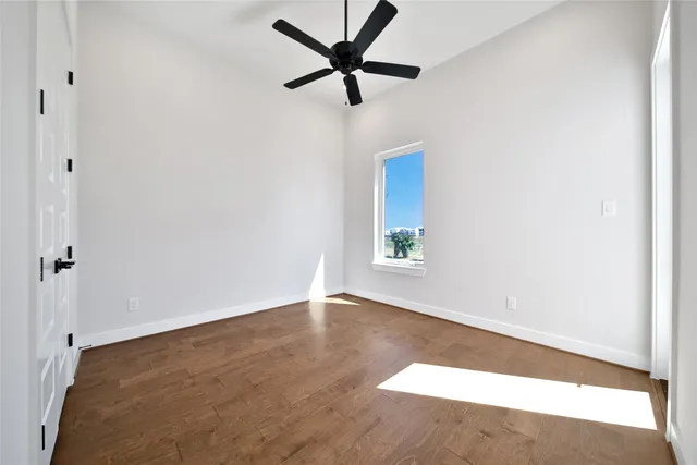an empty room with a window and a fan