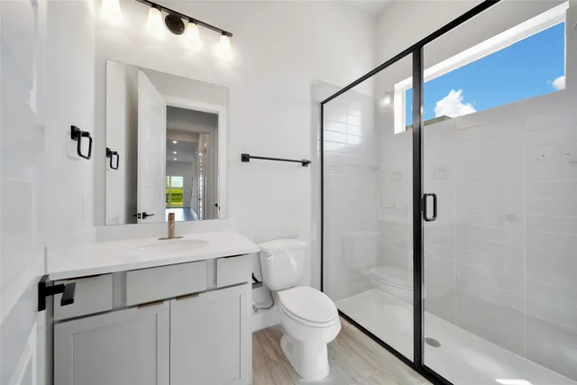 a bathroom with a sink a toilet and shower