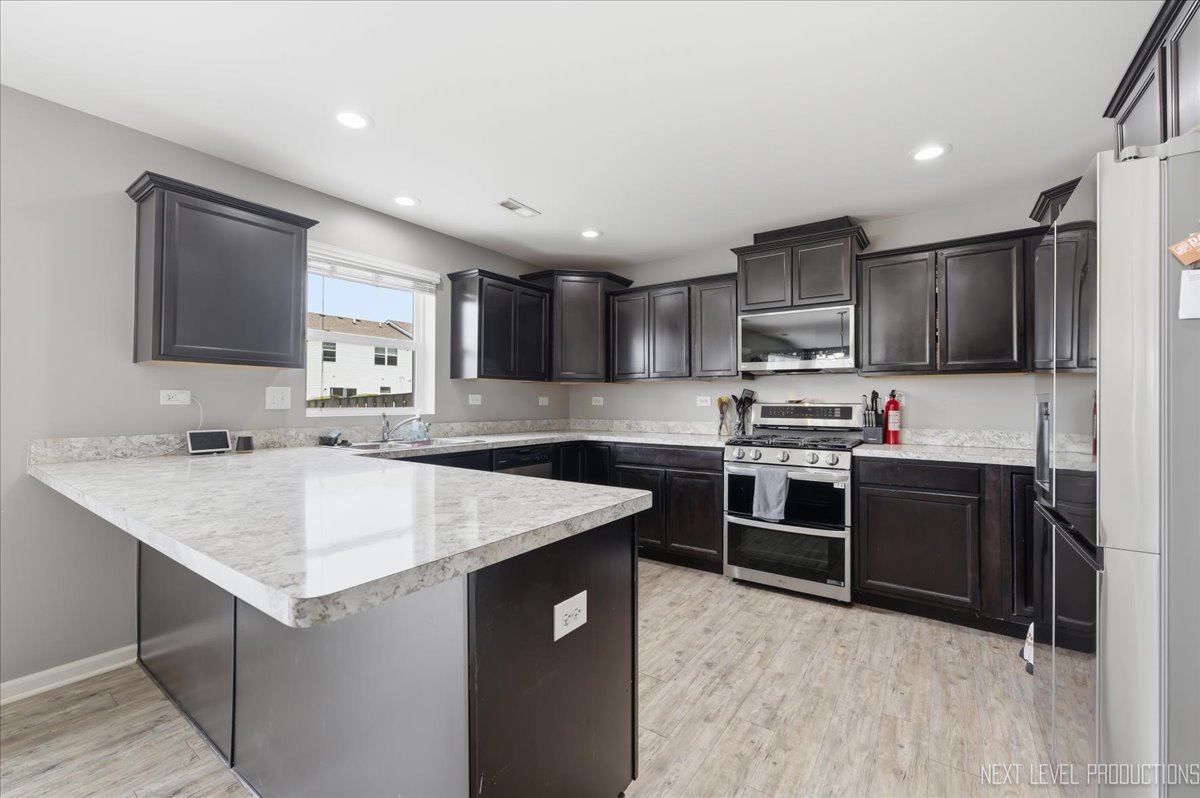270 Norfolk Lane Pingree Grove, IL 60140 - Photo 10 of 25 a kitchen with kitchen island granite countertop a sink stove and refrigerator