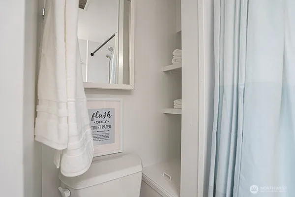 a bathroom with a toilet and a shower curtain