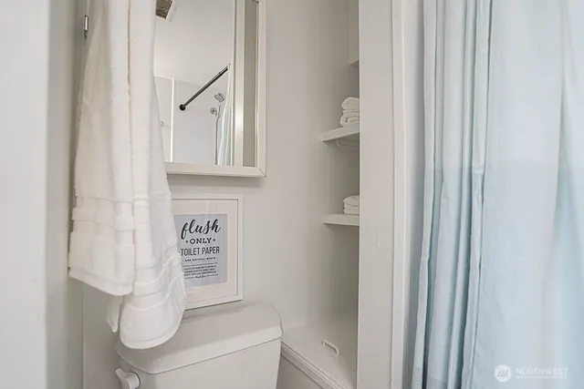 a bathroom with a toilet and a shower curtain