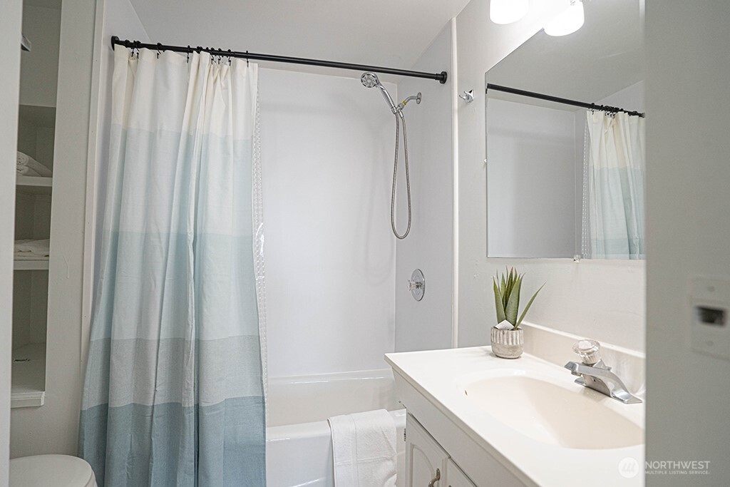 4027 Beach Drive Southwest, Unit 1 Seattle, WA 98116 - Photo 18 of 28 a bathroom with a sink and a mirror
