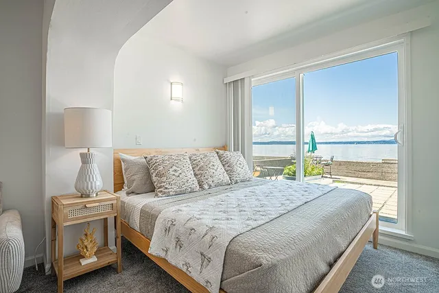 a bedroom with a bed and a large window