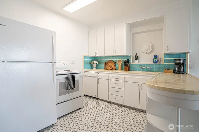 a kitchen with a refrigerator sink and cabinets