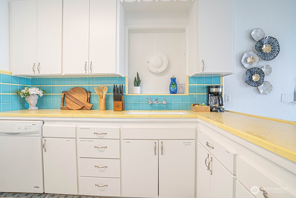 4027 Beach Drive Southwest, Unit 1 Seattle, WA 98116 - Photo 28 of 28 a kitchen with white cabinets and a sink