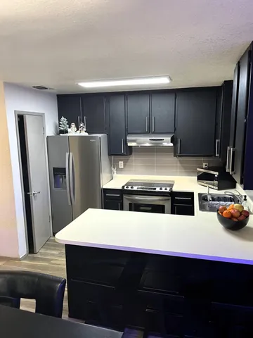 a kitchen with stainless steel appliances a refrigerator and a stove