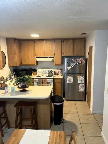 a kitchen with a sink refrigerator and cabinets
