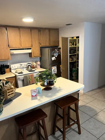 a kitchen with a table chairs and refrigerator