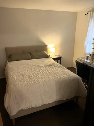 a large bed sitting in a bedroom next to a window