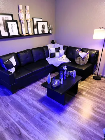 a living room with furniture and a wooden floor