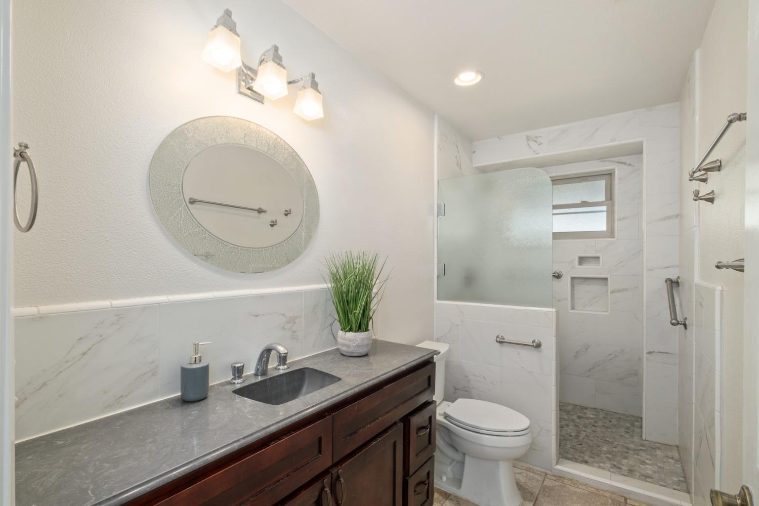 29001 Ave 22 Madera, CA 93638 - Photo 16 of 31 a bathroom with a granite countertop toilet sink and mirror