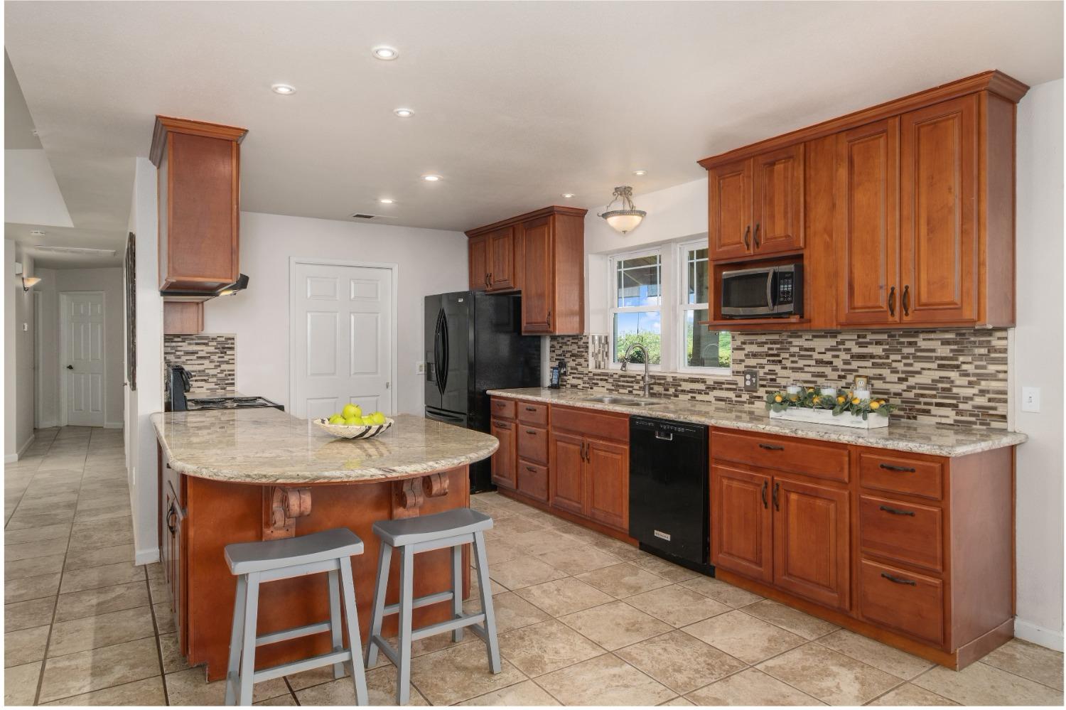 29001 Ave 22 Madera, CA 93638 - Photo 6 of 31 a kitchen with stainless steel appliances granite countertop wooden cabinets a stove top oven a sink and dishwasher